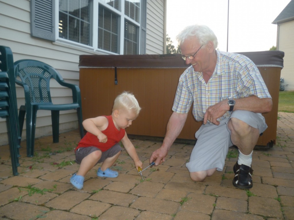 Michiel helpt opa de stoep schoon krabben.